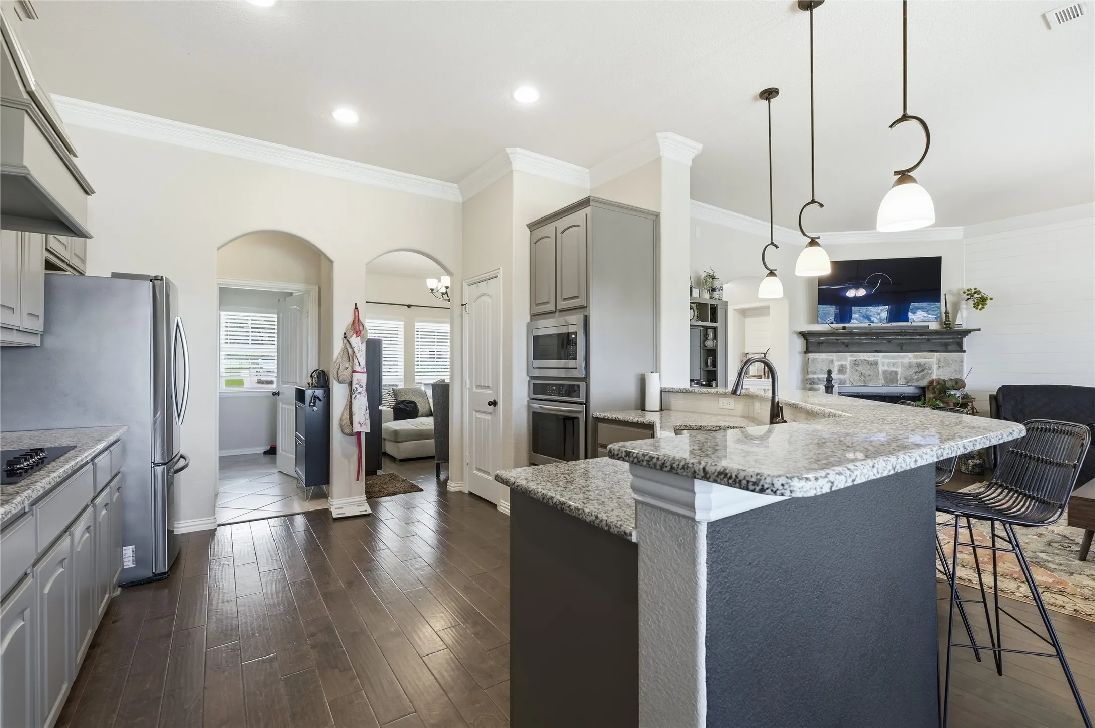 Open-concept kitchen featuring granite countertops and gray cabinetry