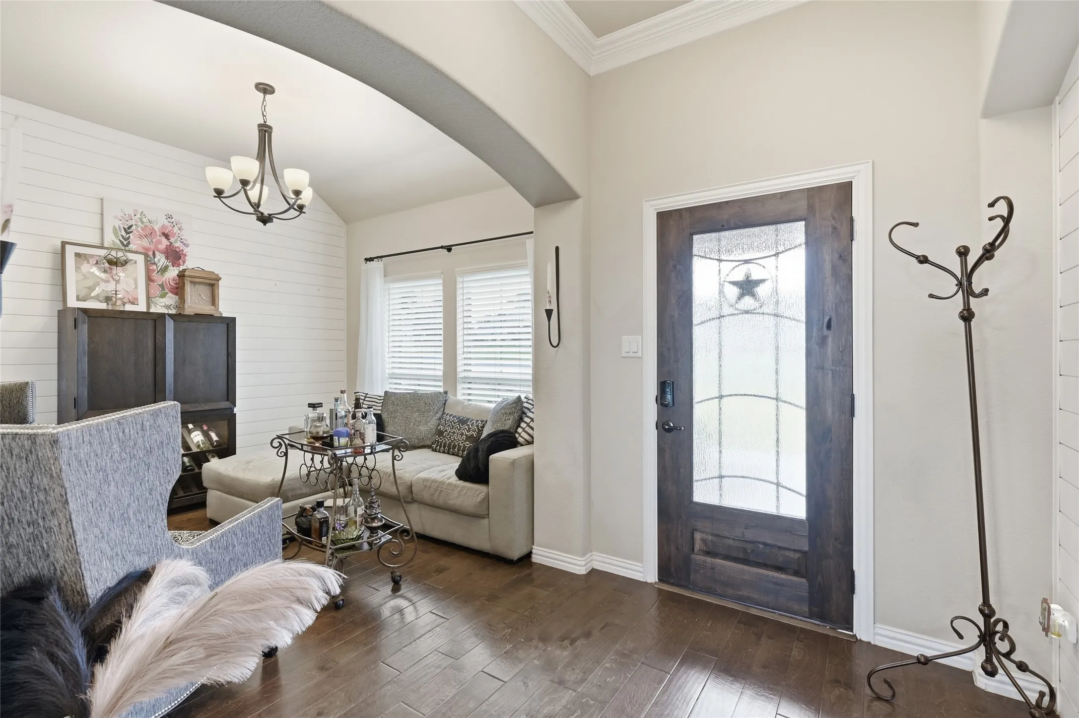 Entryway featuring a dark wood door with decorative glass inserts and a vaulted ceiling