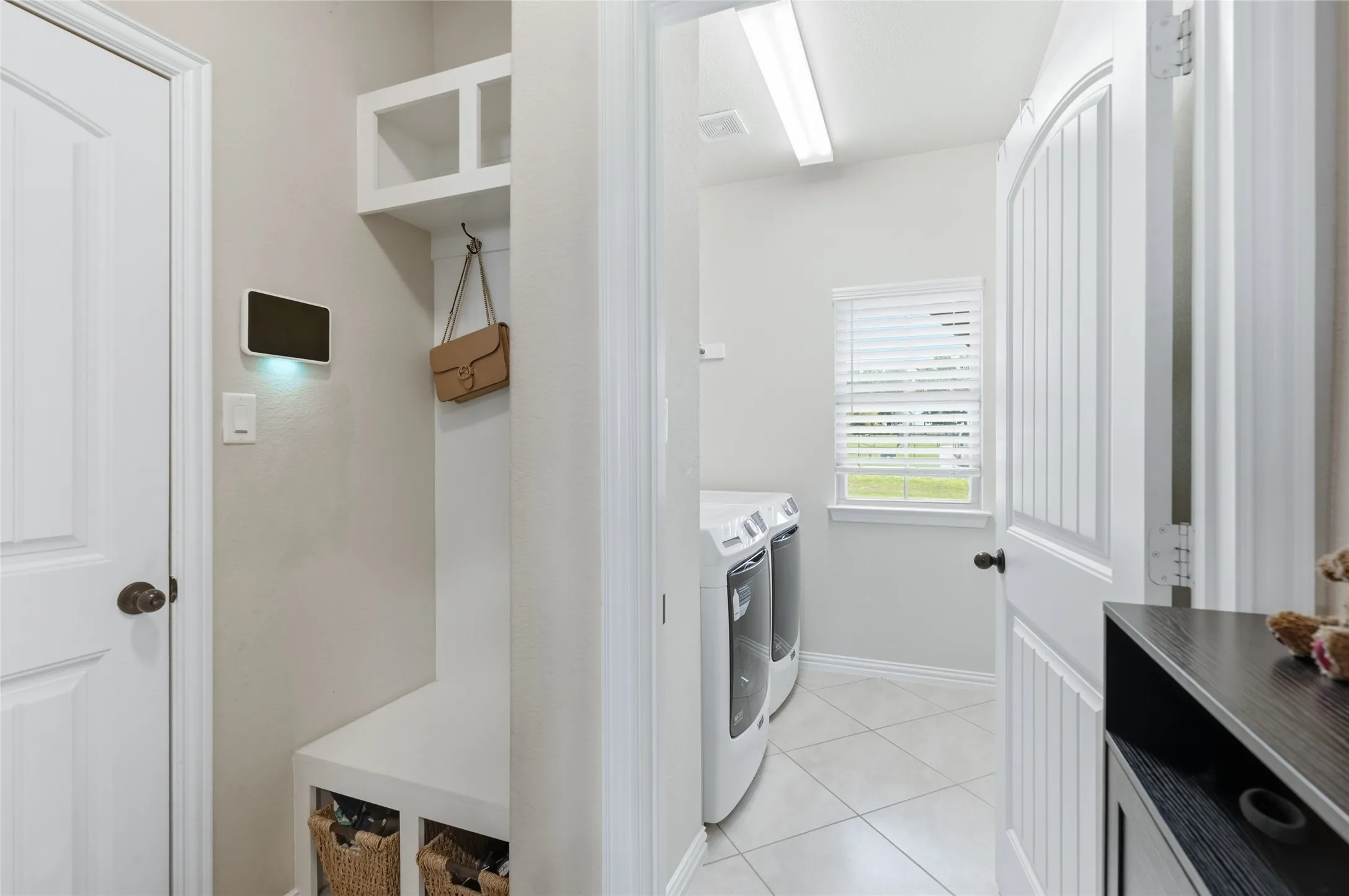 Entryway mudroom featuring built-in storage, bench seating, and an overhead cubby