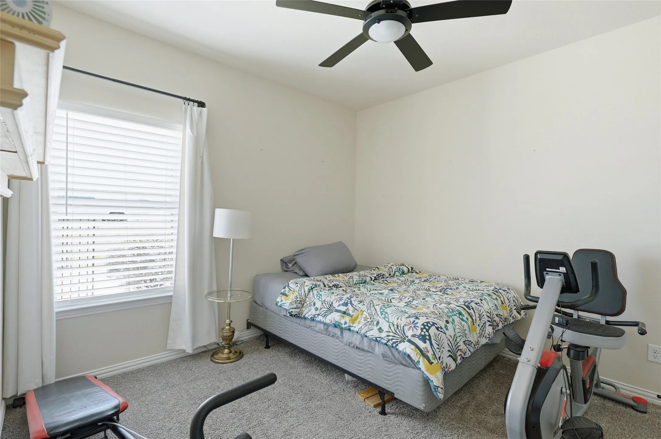 Carpeted room featuring a ceiling fan with integrated lighting