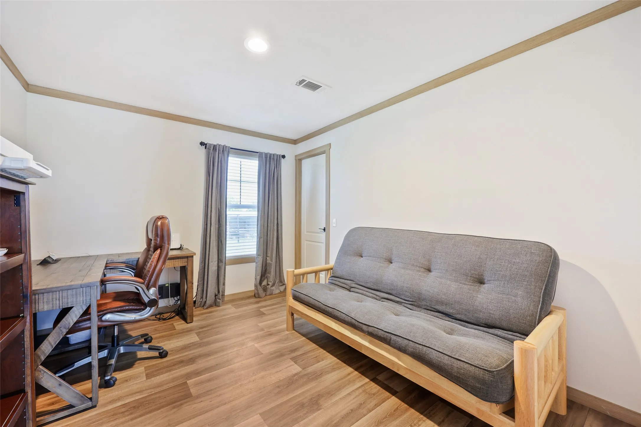 Bright room featuring wood-finish flooring, a window with horizontal blinds, overhead lighting, and crown molding