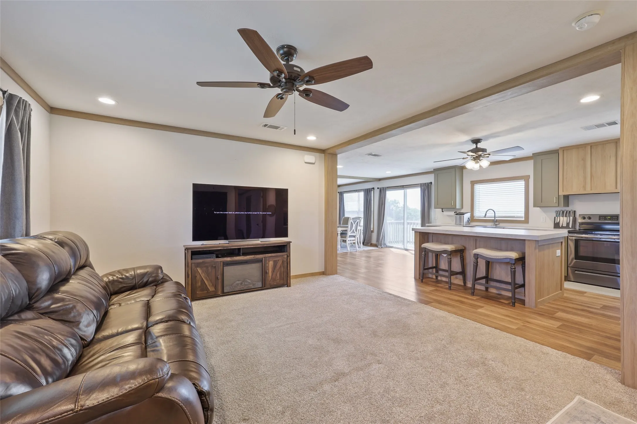 Open-concept living space featuring wood-finish flooring, recessed lighting, and ceiling fans