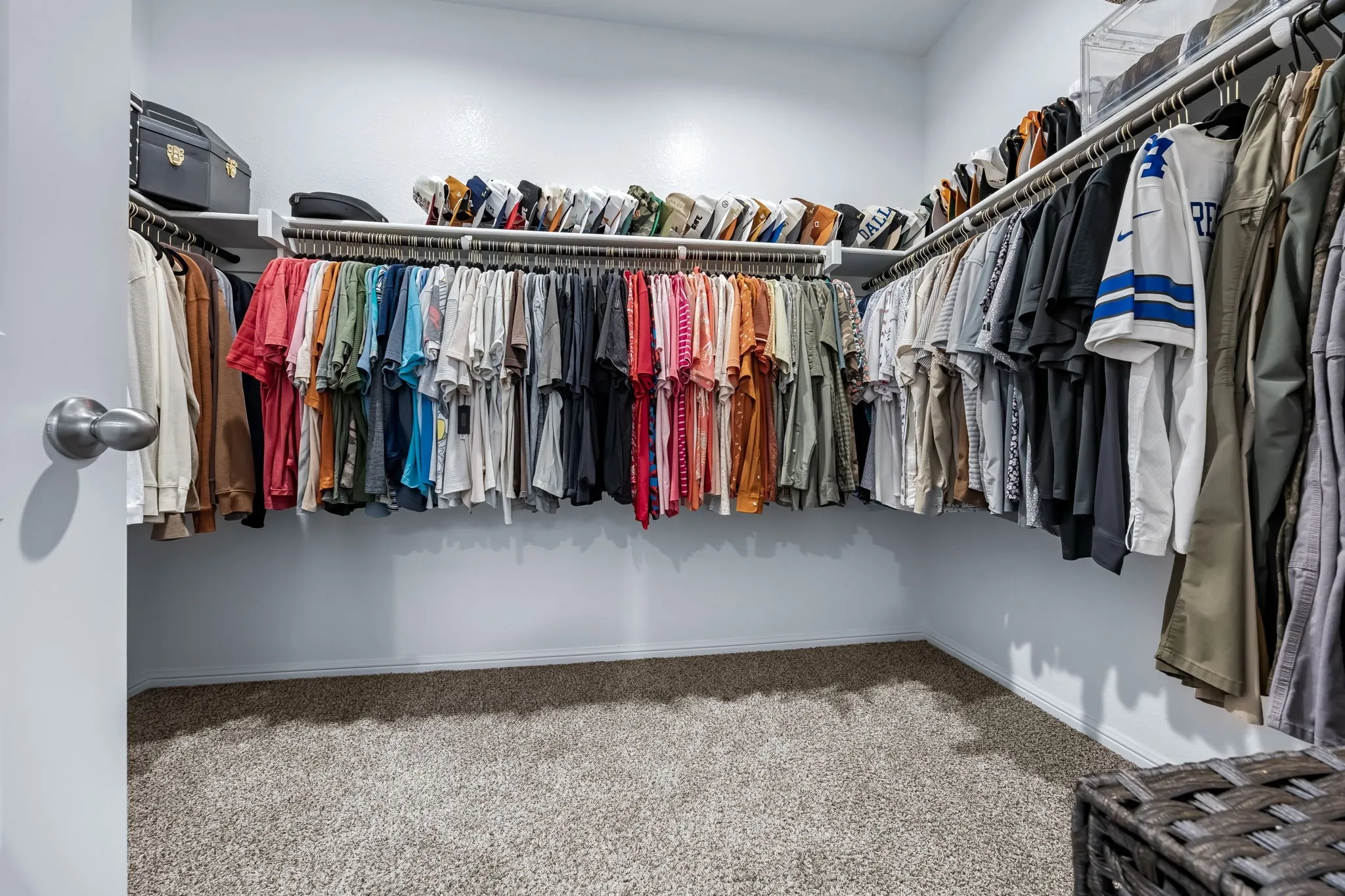 Walk-in closet featuring ample hanging storage, upper shelving, and carpet flooring