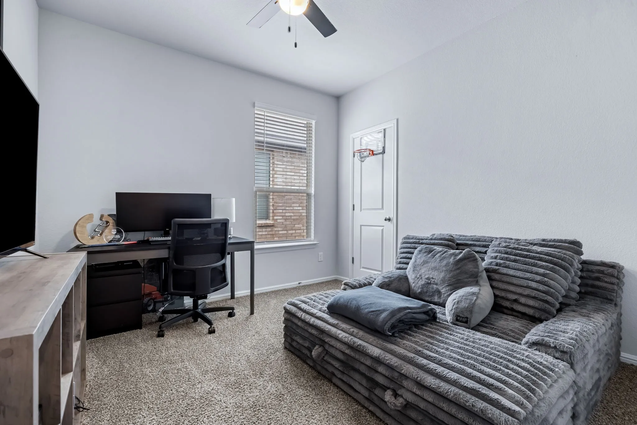Carpeted room with a ceiling fan, a window with blinds, and white walls