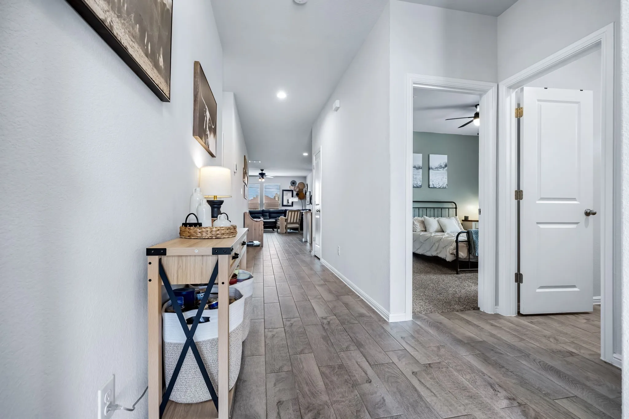 Interior hallway with wood-finish flooring, white walls, and recessed lighting