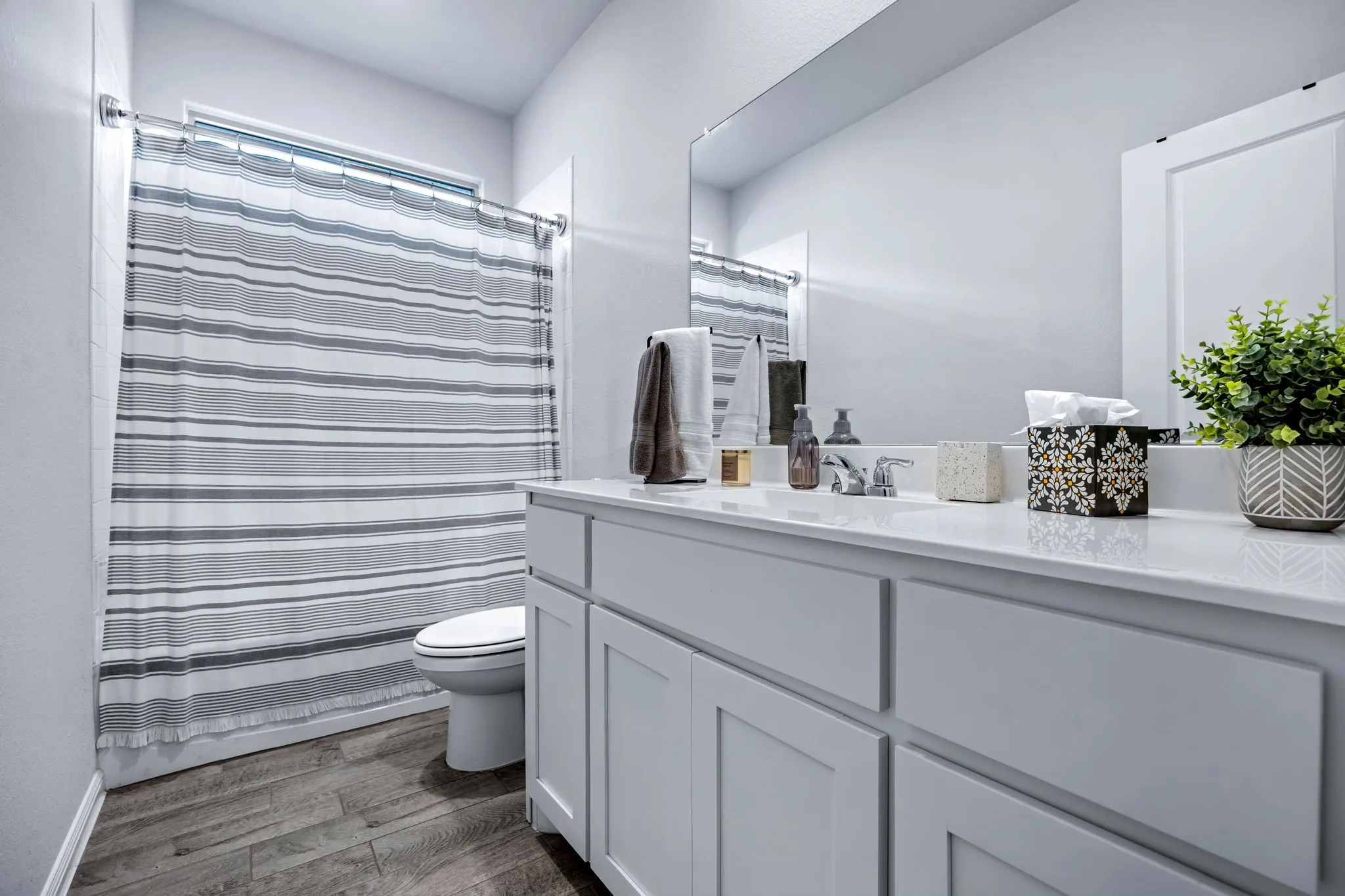 Bathroom featuring a single vanity with white cabinetry and a solid surface countertop
