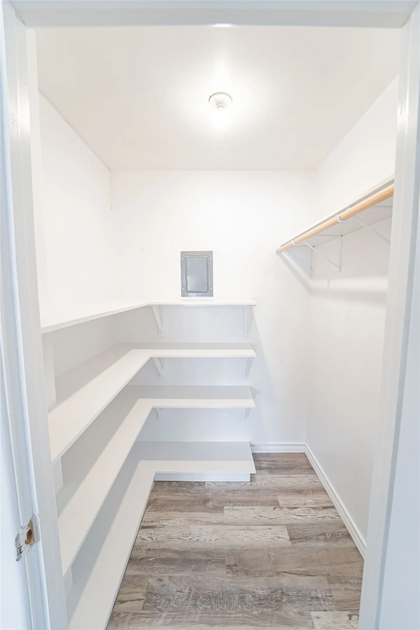 Walk-in closet for 4th bedroom or storage for your flex space- featuring extensive built-in shelving, wood-finish flooring, and overhead lighting-this is an awesome feature!