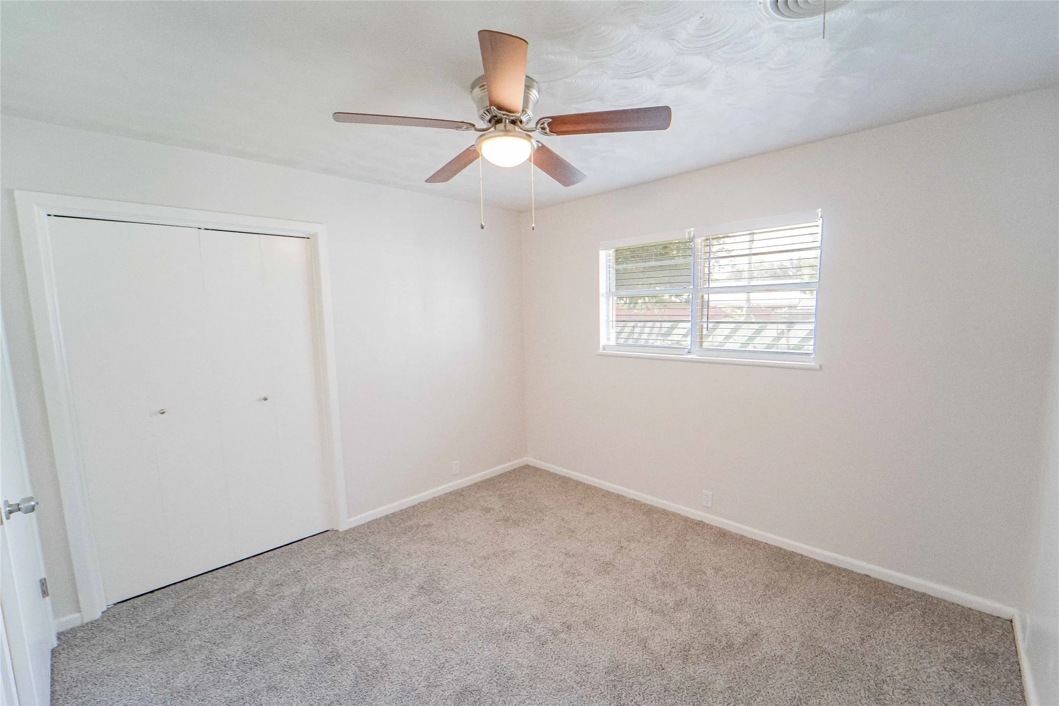 Bedroom 3 of 4/Neutral wall color featuring new carpet, blinds, and a ceiling fan with integrated lighting