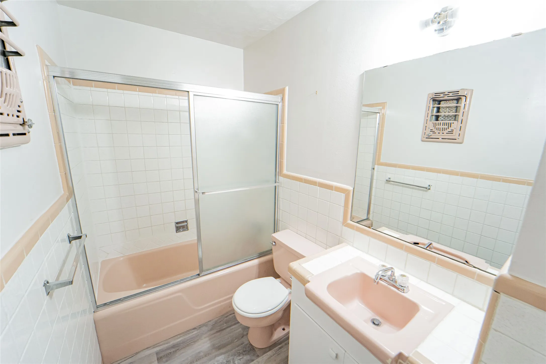 Guest Bathroom featuring a porcelain vanity with integrated sink, white tiled walls with an accent border, and tub/shower combo.