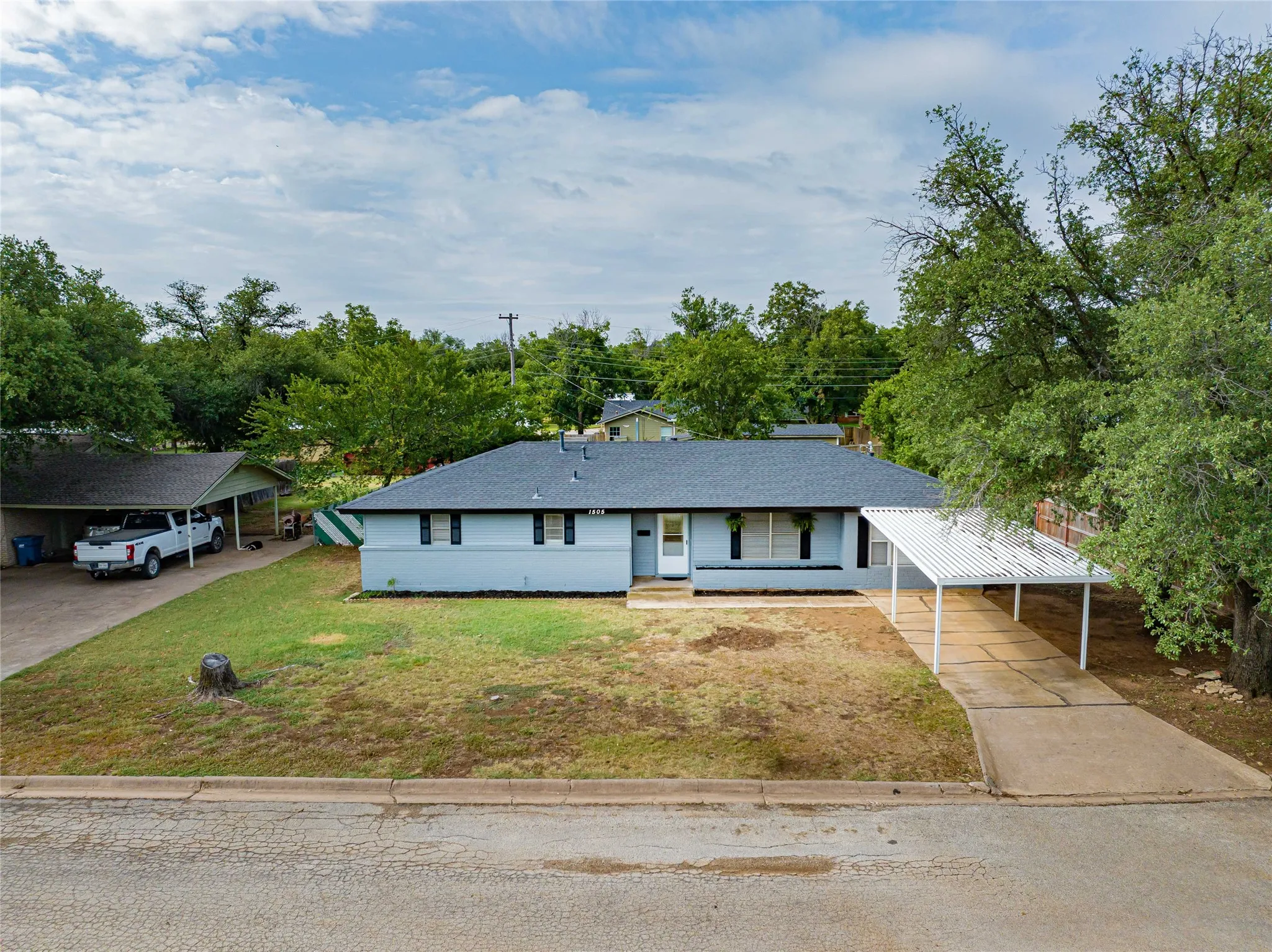 Newly renovated, 4 Bedroom, 2 Bathroom, Sunroom, Covered Parking- all located in a quiet and established neighborhood! Ranch-style residence featuring a light gray exterior, dark shutters, and a dark shingle roof