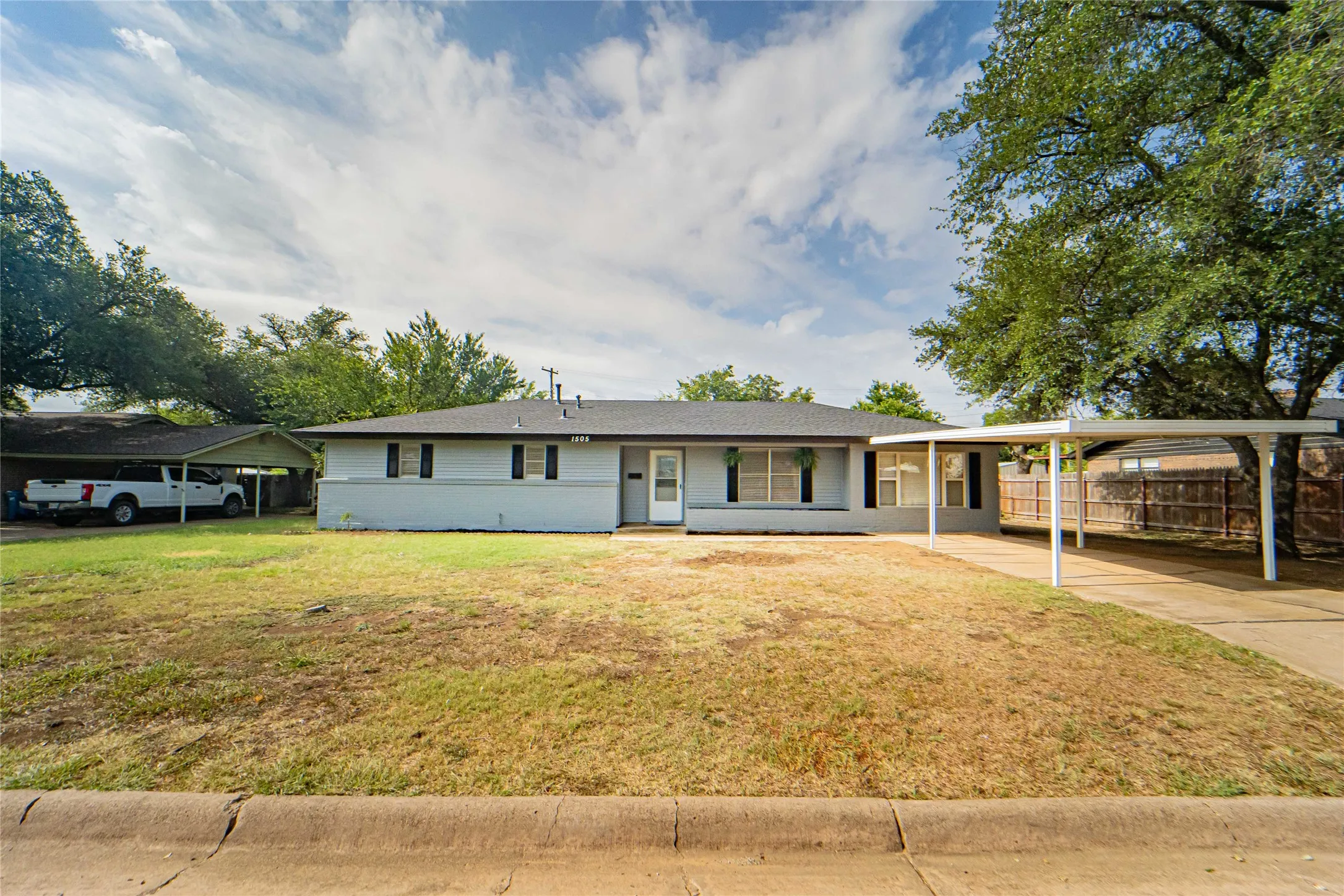 Newly renovated, 4 Bedroom, 2 Bathroom, Sunroom, Covered Parking- all located in a quiet and established neighborhood! Ranch-style residence featuring a light gray exterior, dark shutters, and a dark shingle roof
