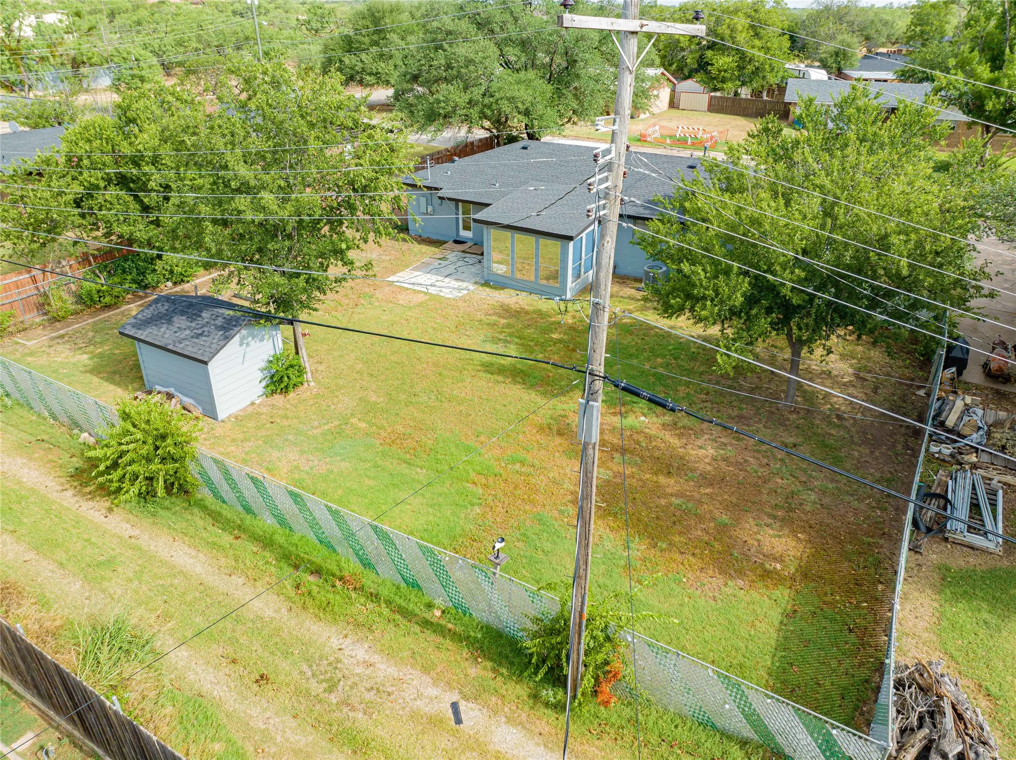 Great backyard for work or play, alley access is a bonus! Expansive green space featuring a dedicated work shop/storage building, chain-link fence and mature trees.