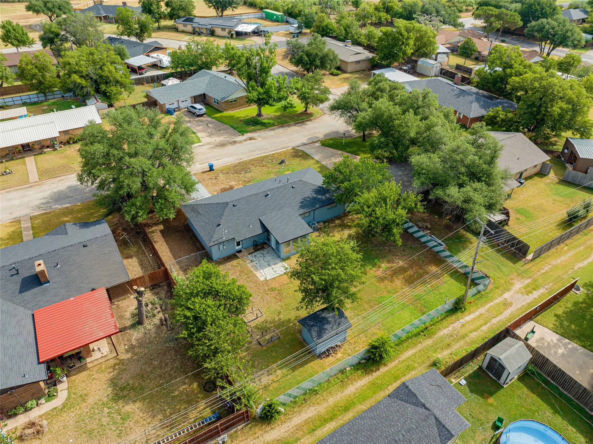 Expansive backyard with a storage shed, mature trees, and a partial privacy fence-alley access!