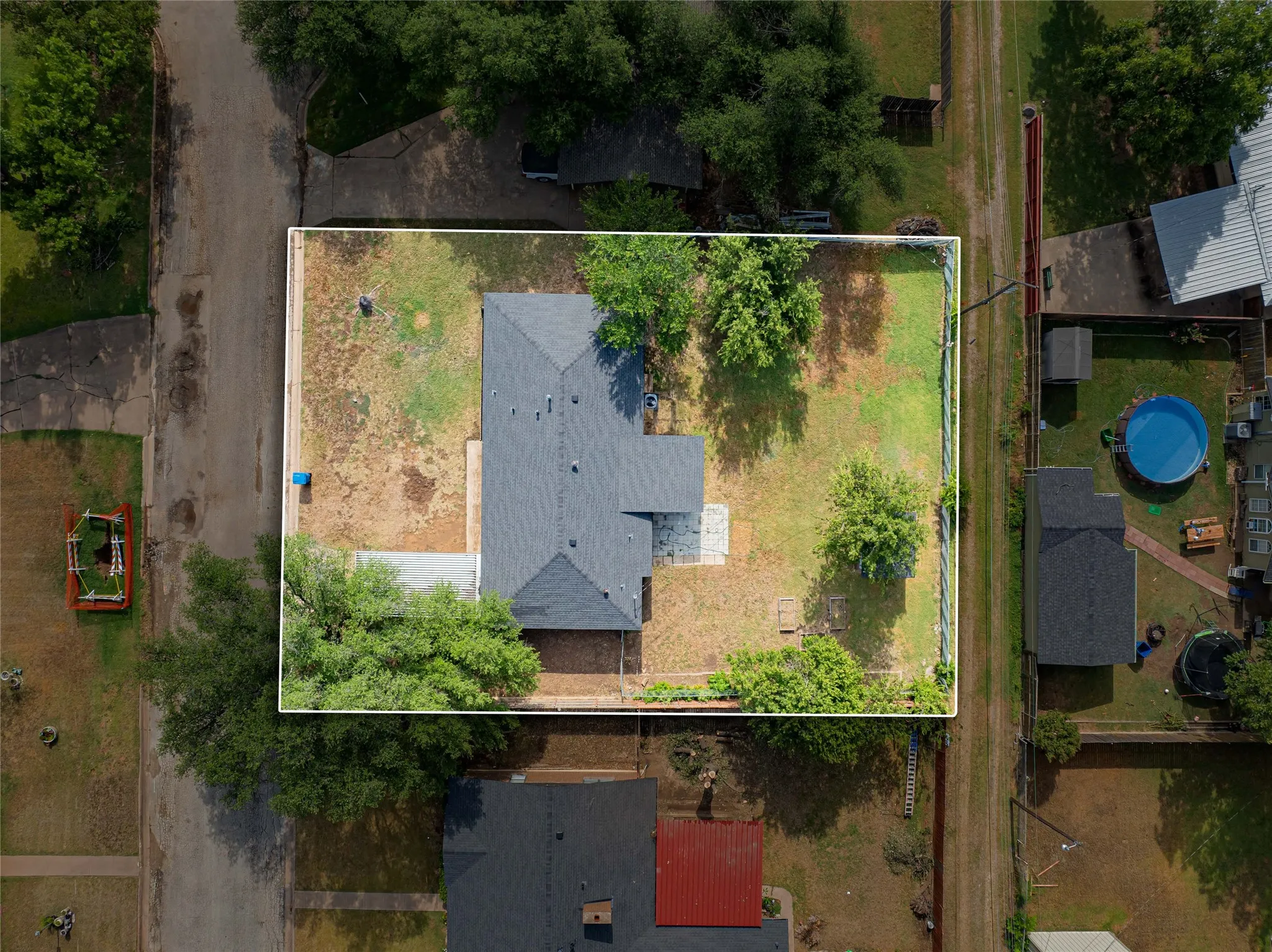Aerial perspective showcasing large lot, a fenced perimeter, and mature trees in a large back yard. Plenty of room to entertain, relax, plant your own garden if you like!