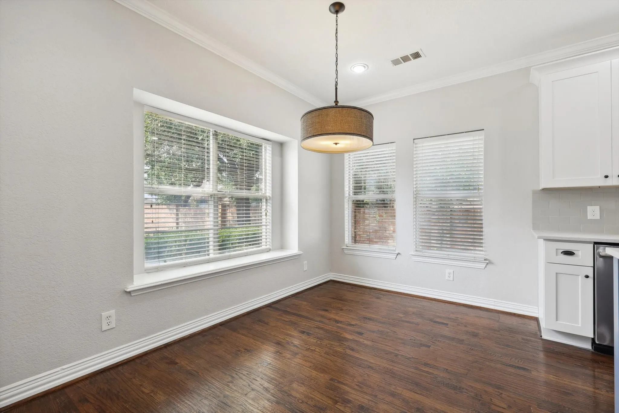 Unfurnished dining area with dark hardwood / wood-style floors and crown molding