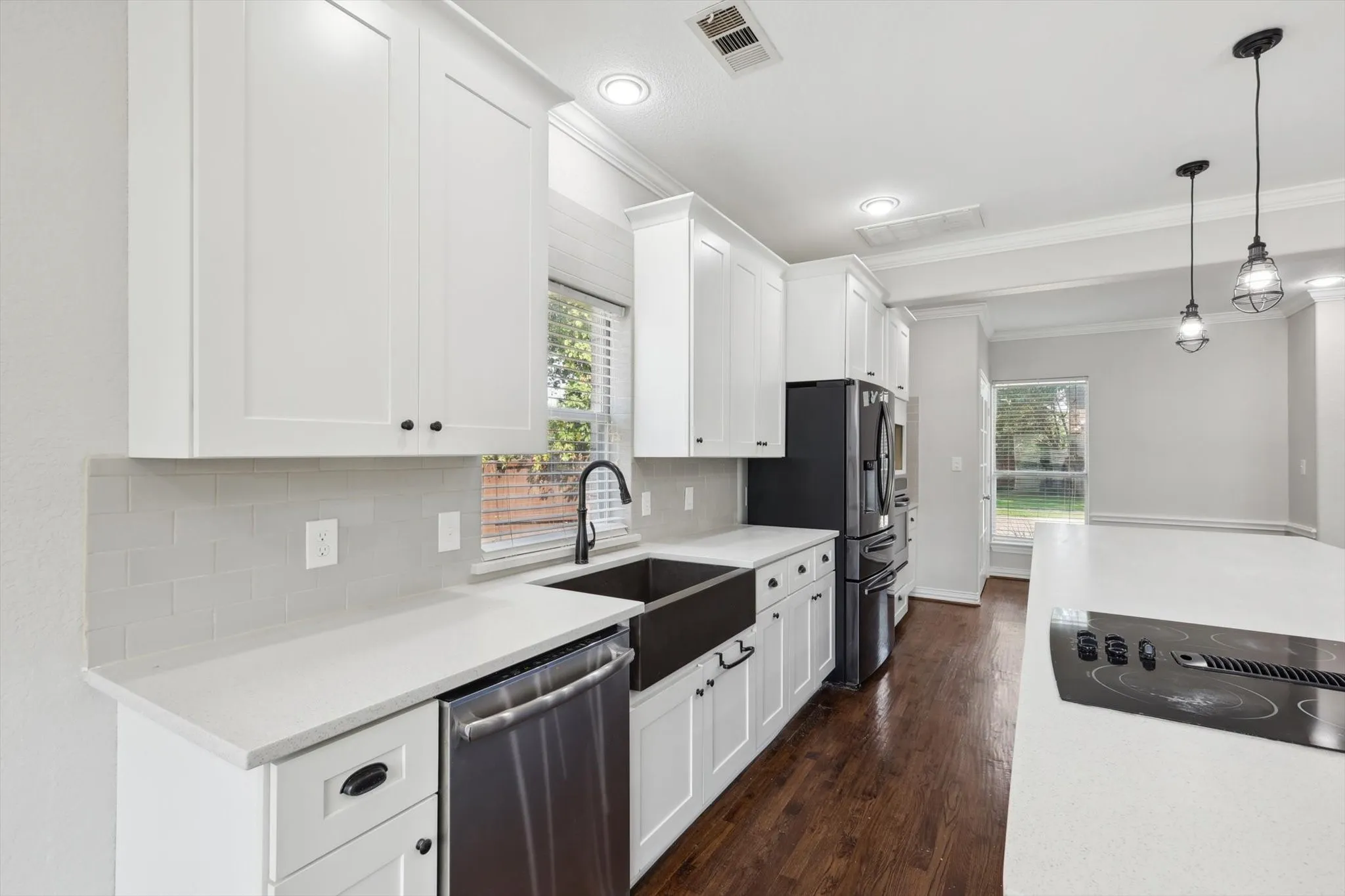 Kitchen featuring appliances with stainless steel finishes, tasteful backsplash, crown molding, and plenty of natural light