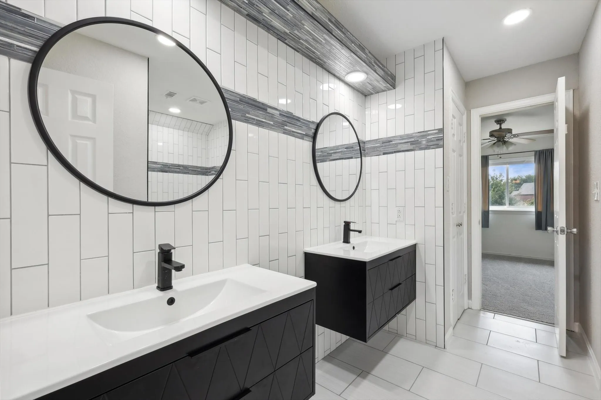 Bathroom with ceiling fan, tile walls, tile patterned floors, and dual vanity