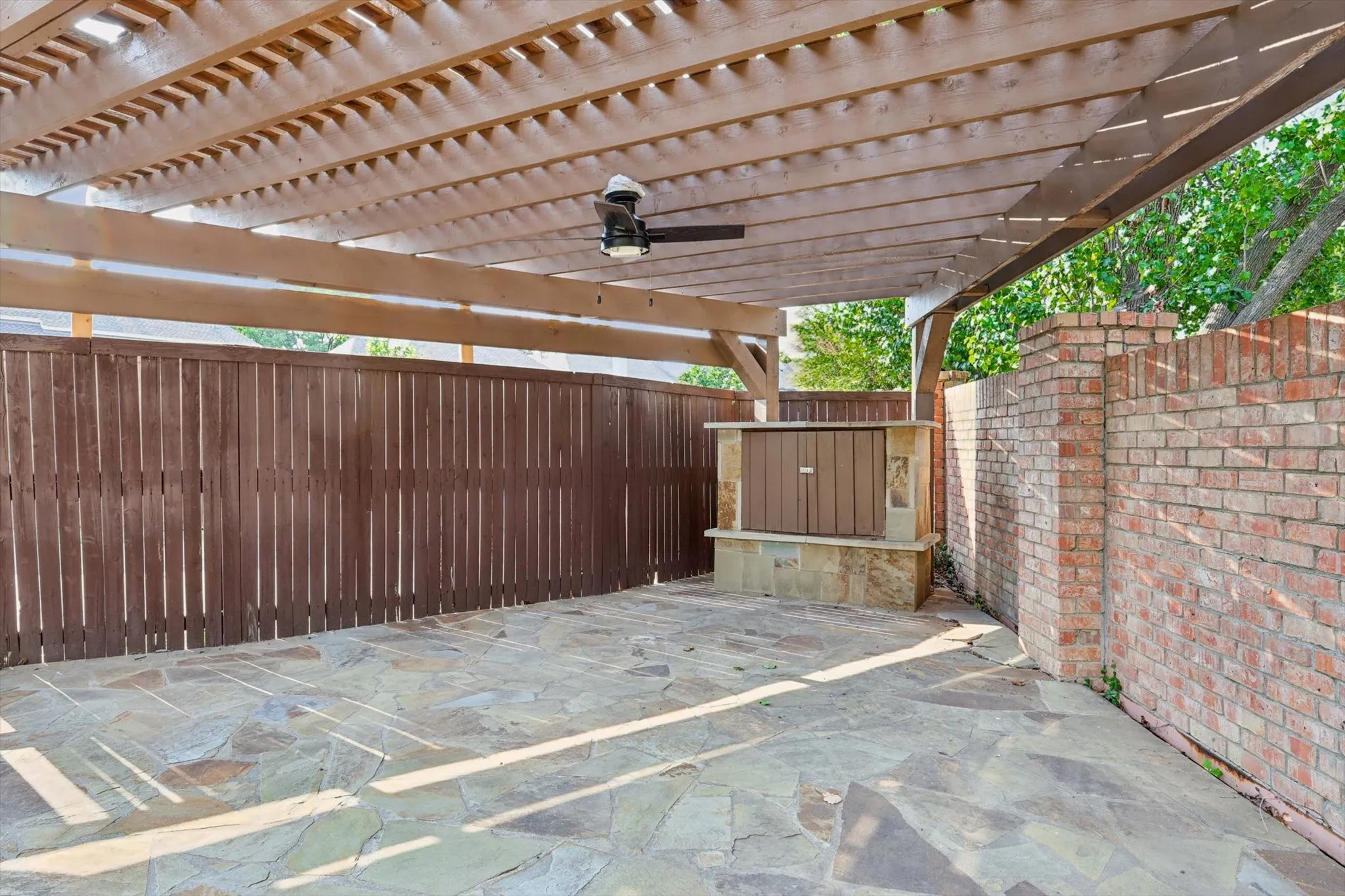 View of patio featuring a pergola, small entertainment center.
