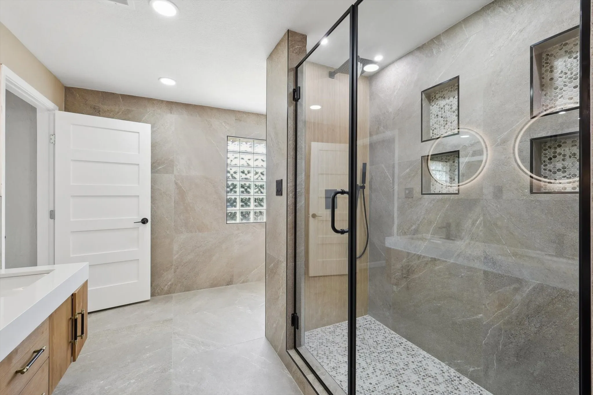 Bathroom with tile walls, vanity, and a shower with shower door