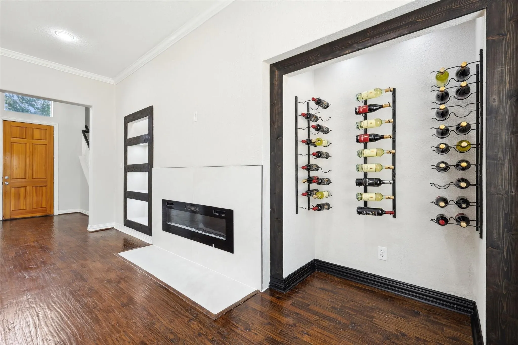 Wine area featuring dark hardwood / wood-style flooring and ornamental molding
