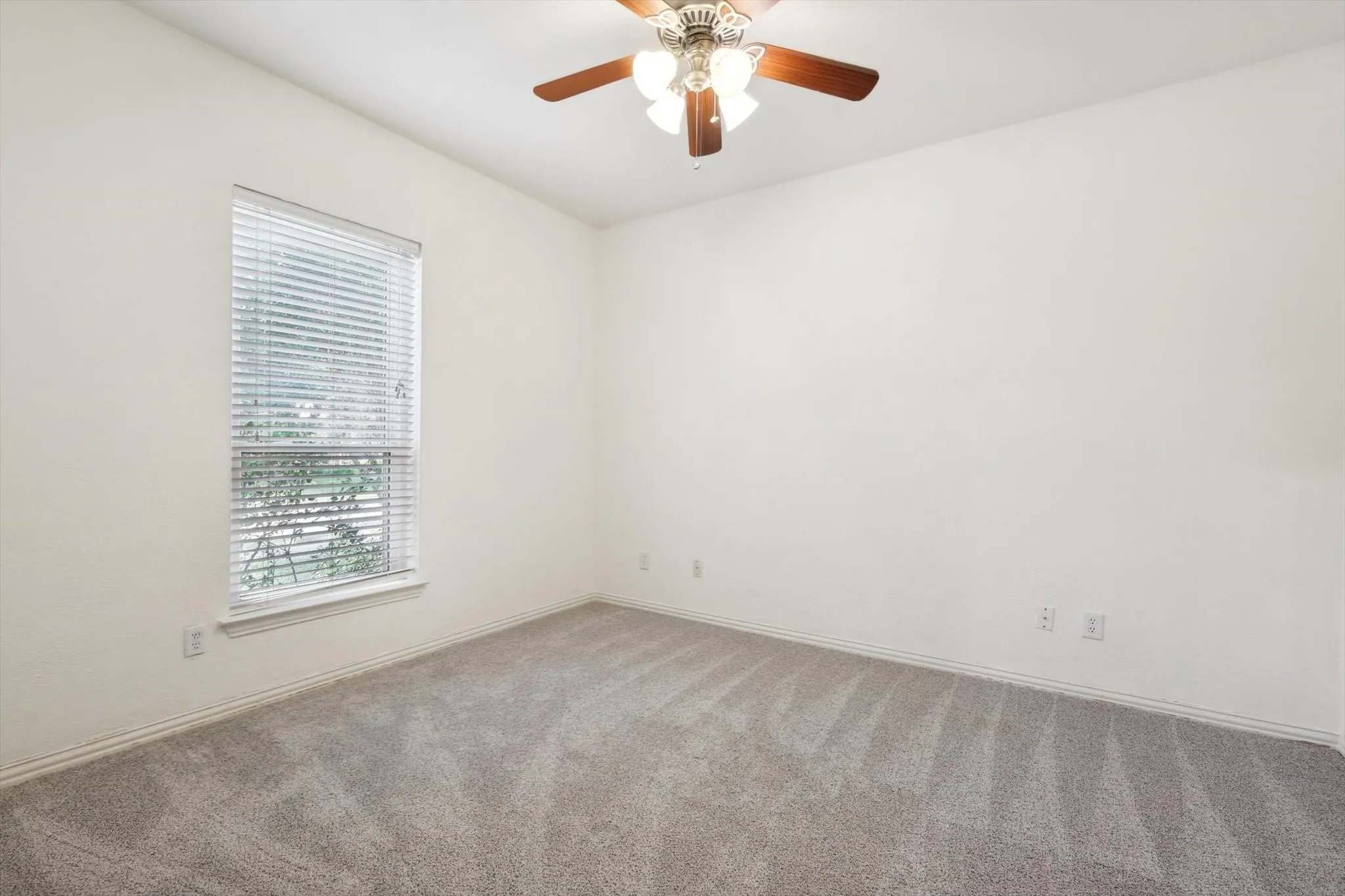 Carpeted empty room with ceiling fan