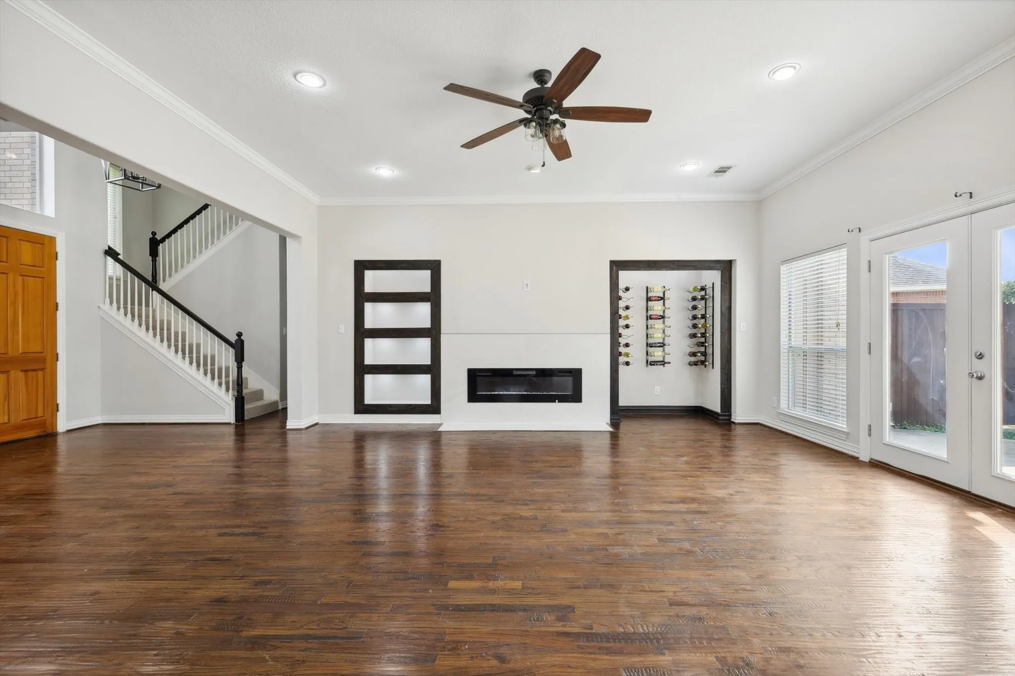 Unfurnished living room with ceiling fan, a healthy amount of sunlight, hardwood / wood-style flooring, and crown molding