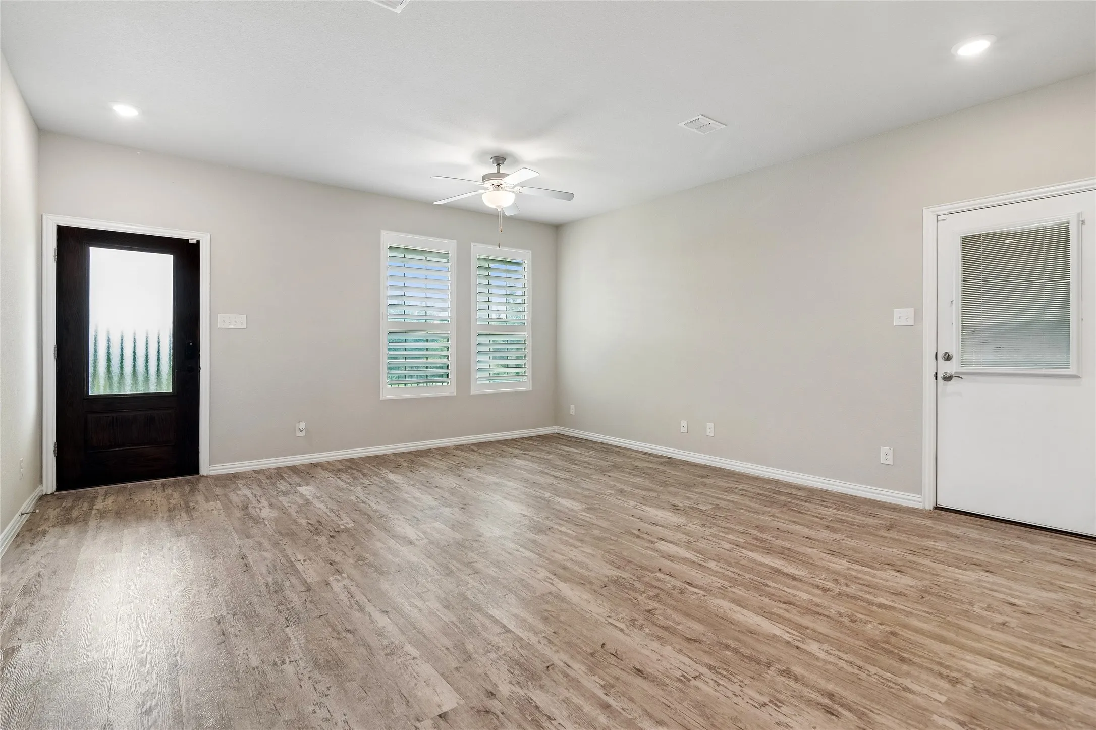 Living room showing front door and side door out to backyard