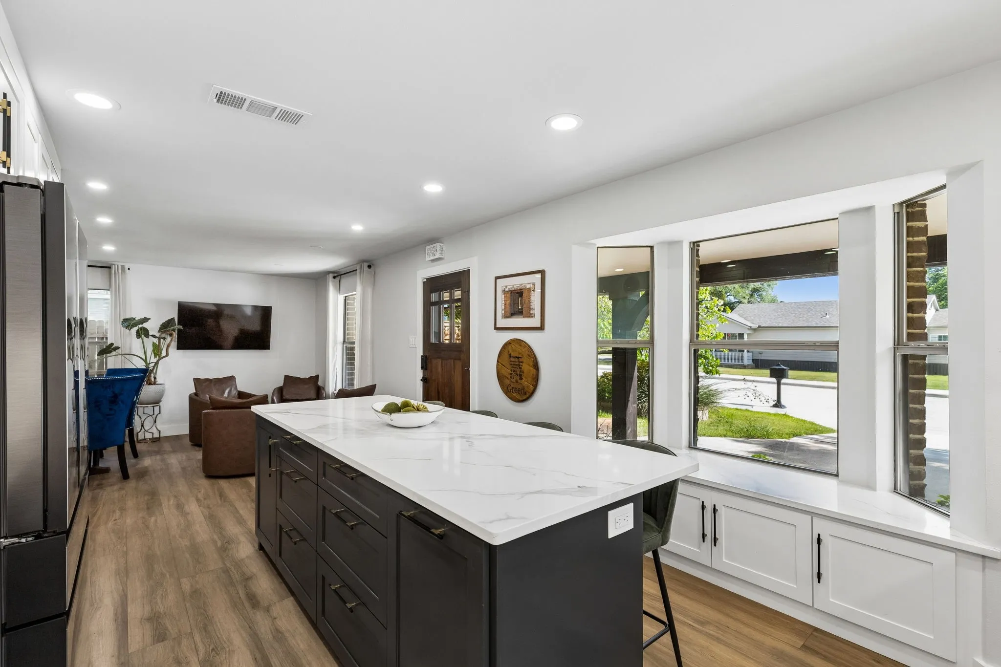 Kitchen island with a white stone-look countertop and dark cabinetry
