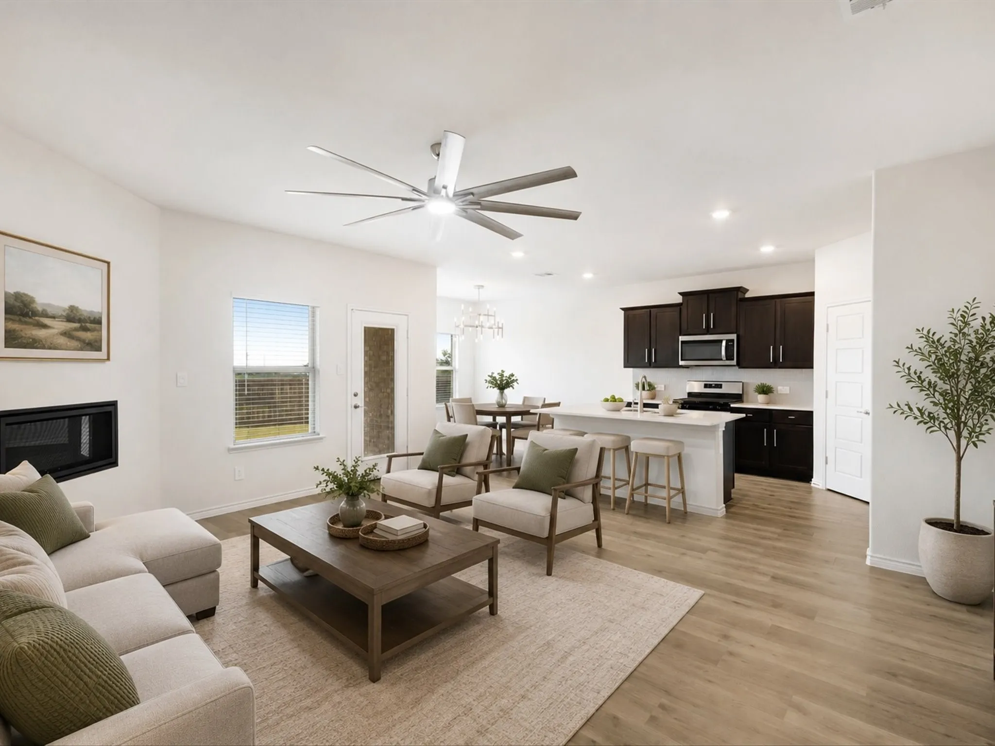 Open living room including a fireplace with seamless flow to the dining and kitchen areas. Virtually Staged