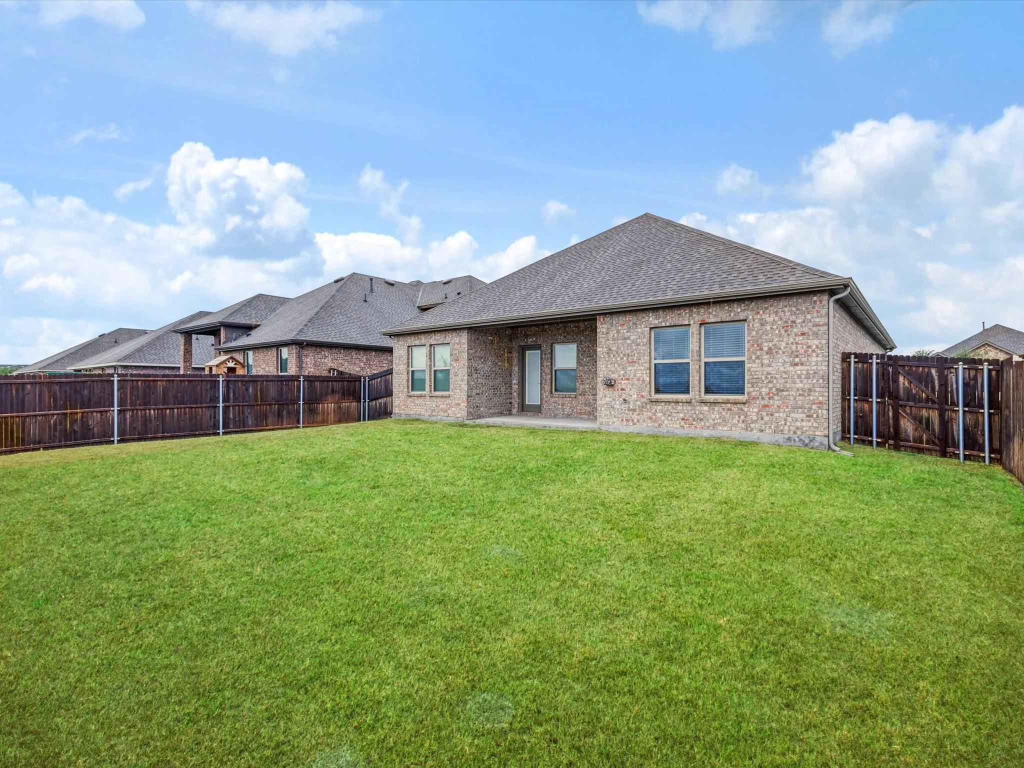 Spacious backyard with covered patio and privacy fence