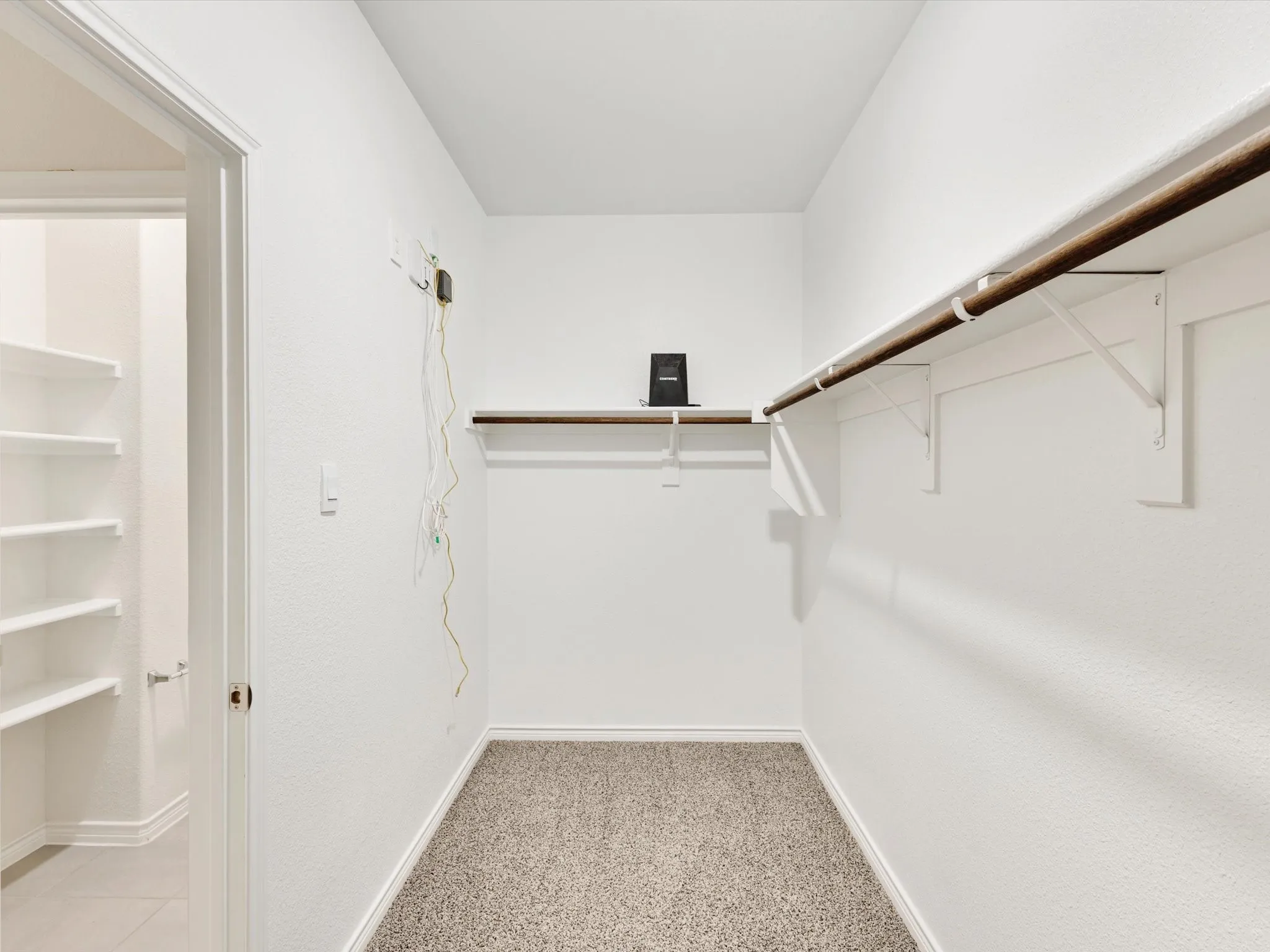 Large walk-in closet with built-in shelving and hanging space