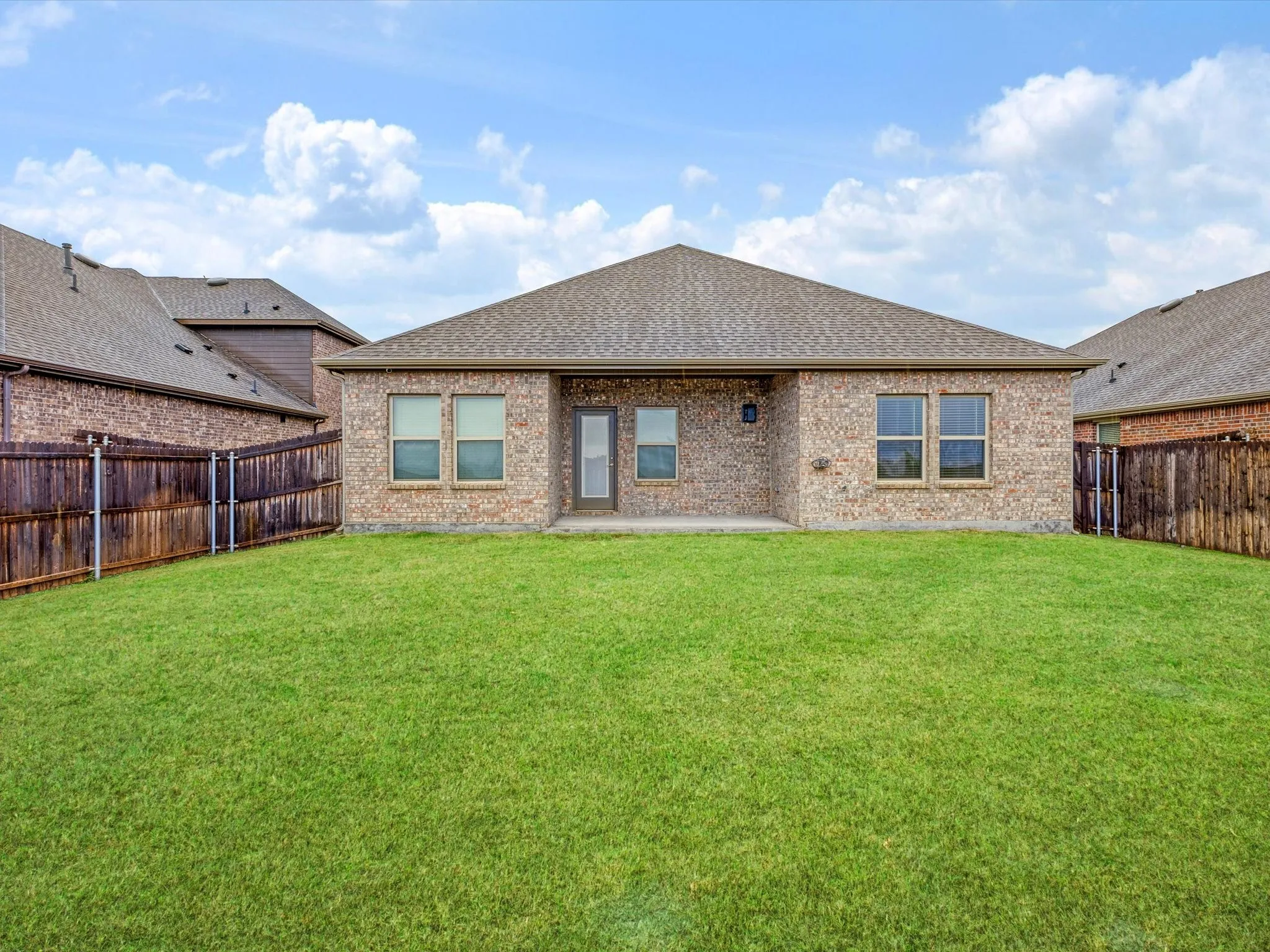 Fully fenced backyard with a covered patio and plenty green space