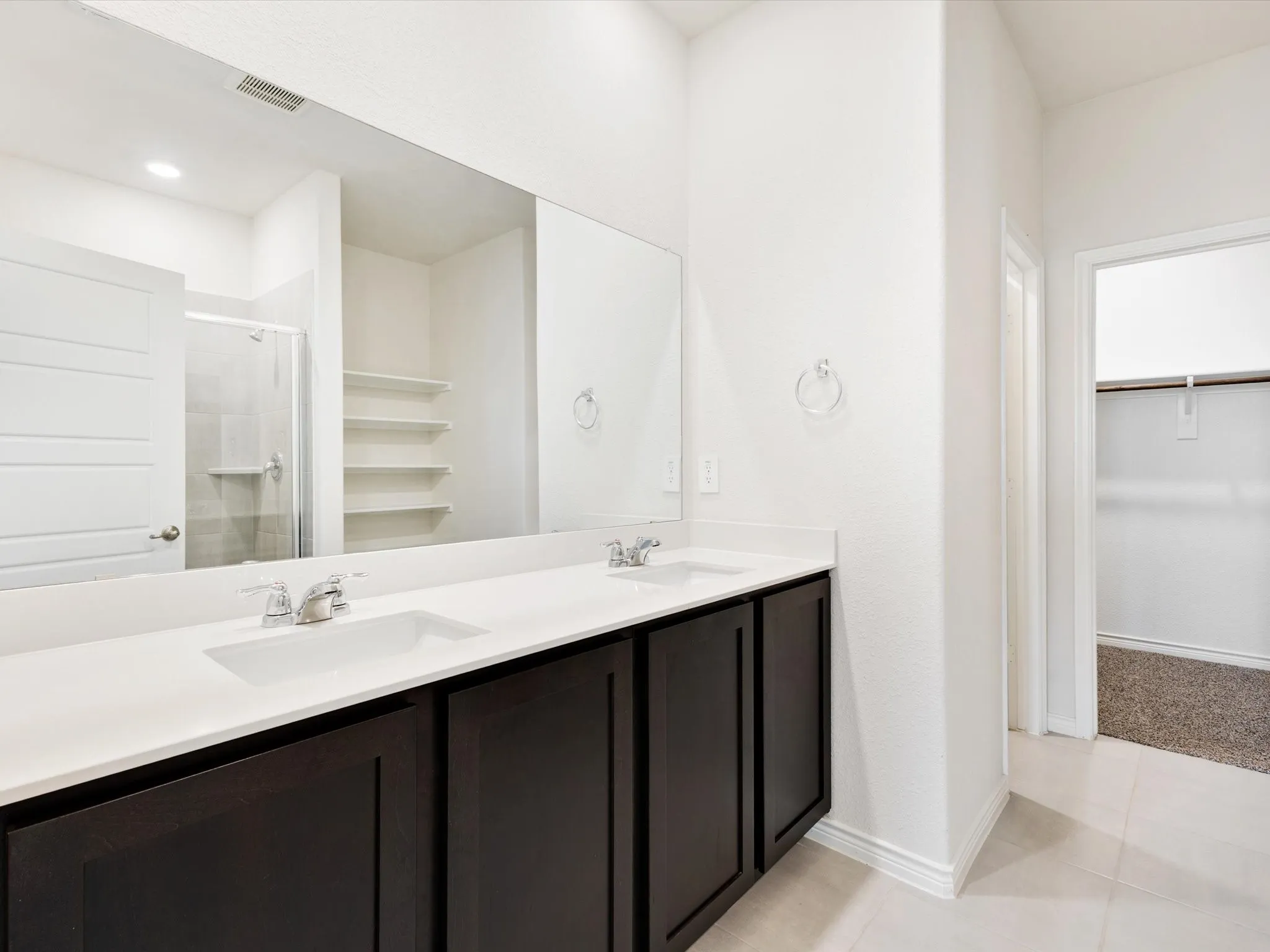 Primary bathroom with dual- sink vanity and generous counter space.