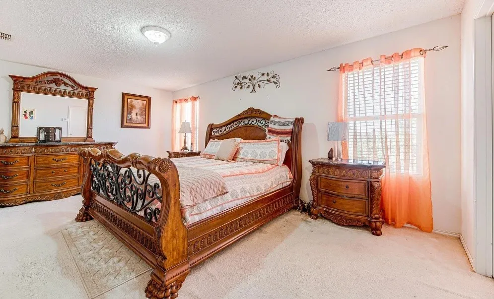 Carpeted room featuring a ceiling-mounted light fixture and two windows with blinds