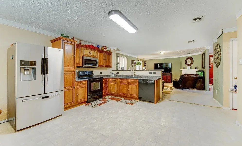 Kitchen featuring stainless steel appliances, wood cabinetry, built-in microwave, and a breakfast bar