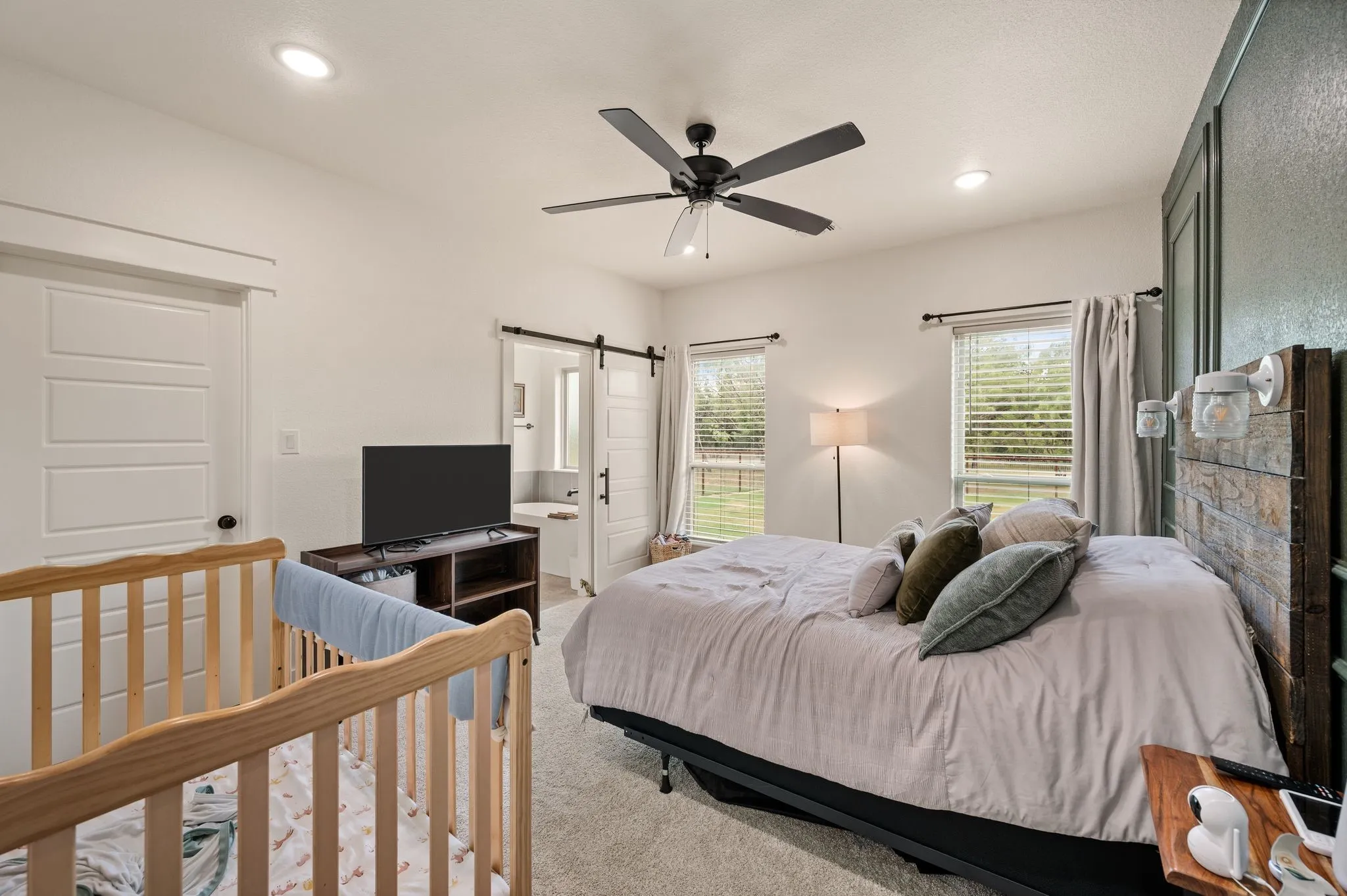 Spacious bedroom featuring recessed lighting, a ceiling fan, and two windows with blinds