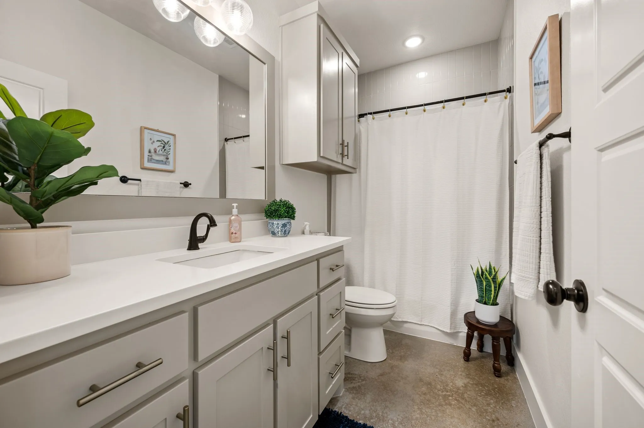 Bathroom featuring a vanity with an integrated sink, light-toned countertop, and light gray cabinetry