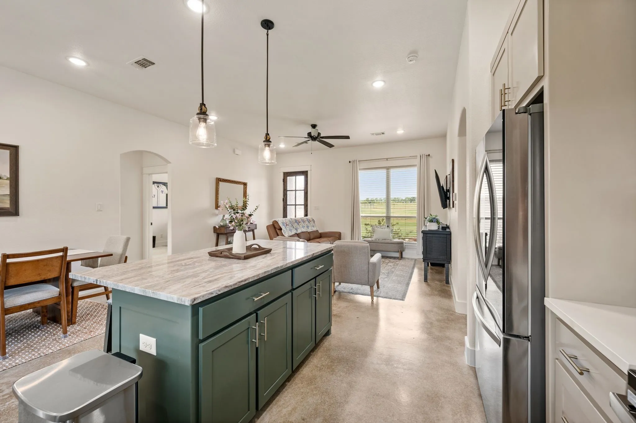 Central kitchen island with a light-toned countertop, deep green cabinetry, and pendant​​‌​​​​‌​​‌‌​‌‌​​​‌‌​‌​‌​‌​​​‌​​ lighting