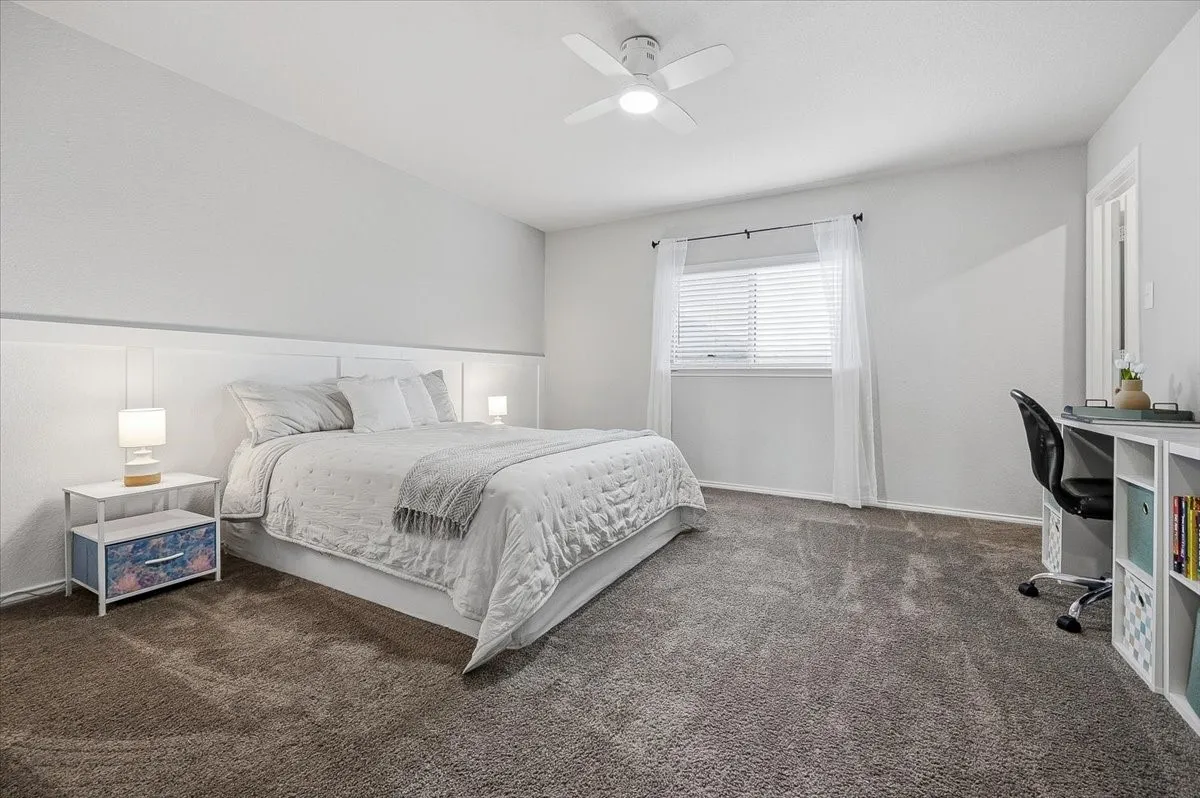 Oversized, light-filled secondary bedroom with room for a desk, sitting area, or play space.