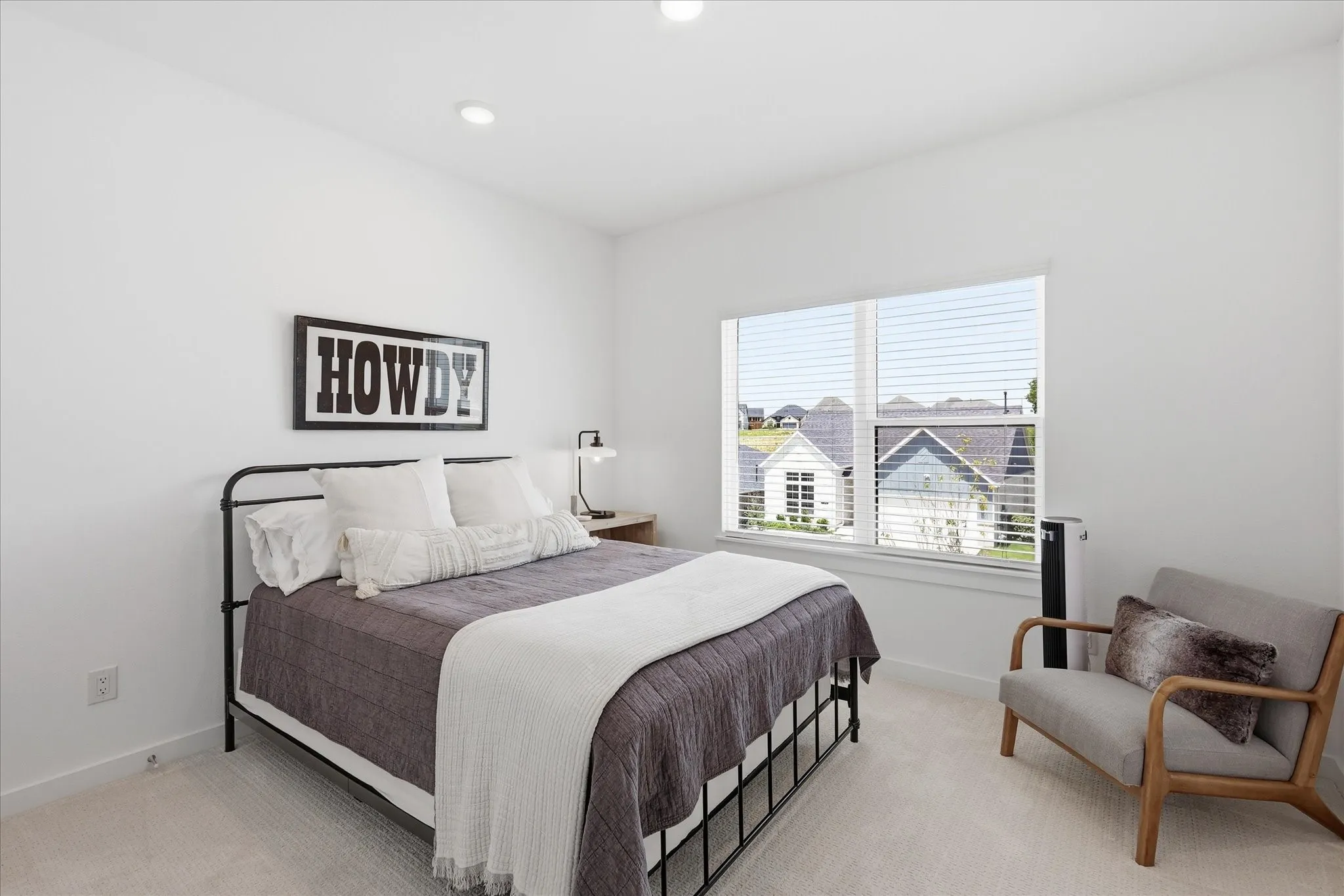 Bedroom that is washed in natural light from the large windows.