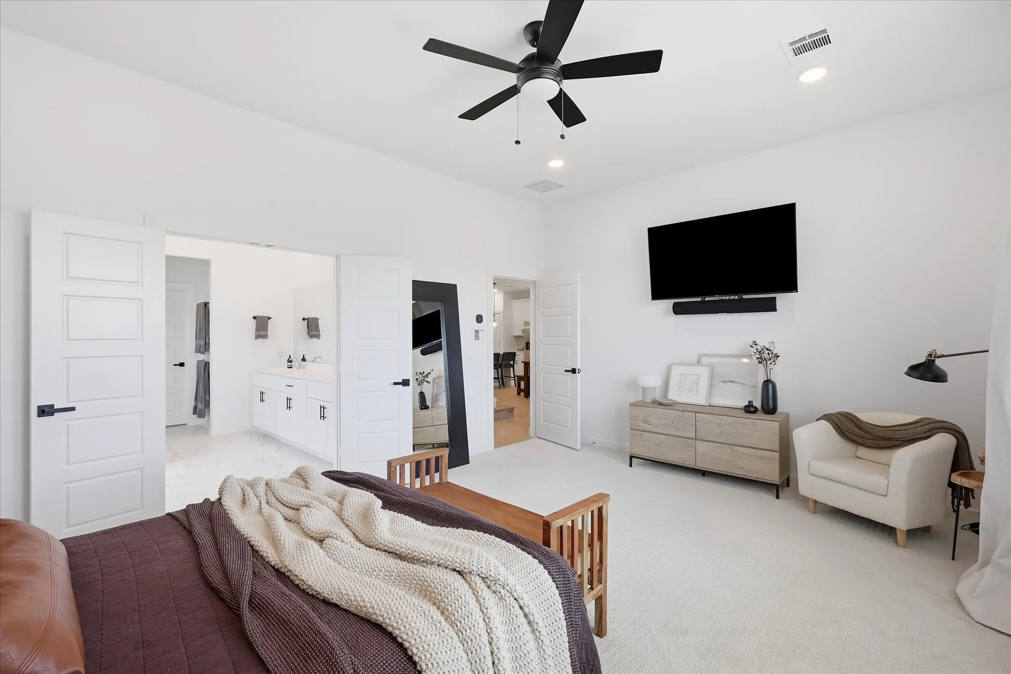 Expansive room featuring clean white walls, recessed lighting, and a ceiling fan