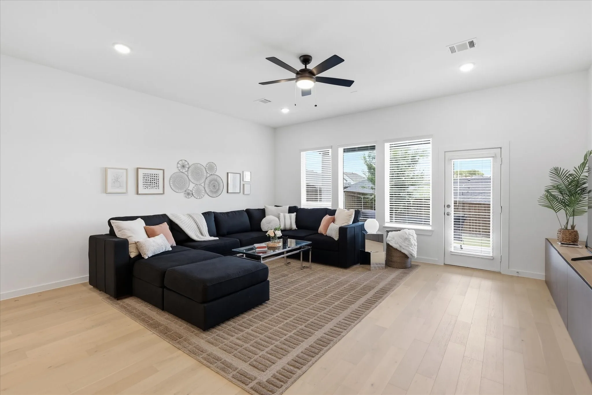 Spacious living area with light wood flooring and abundant natural light.