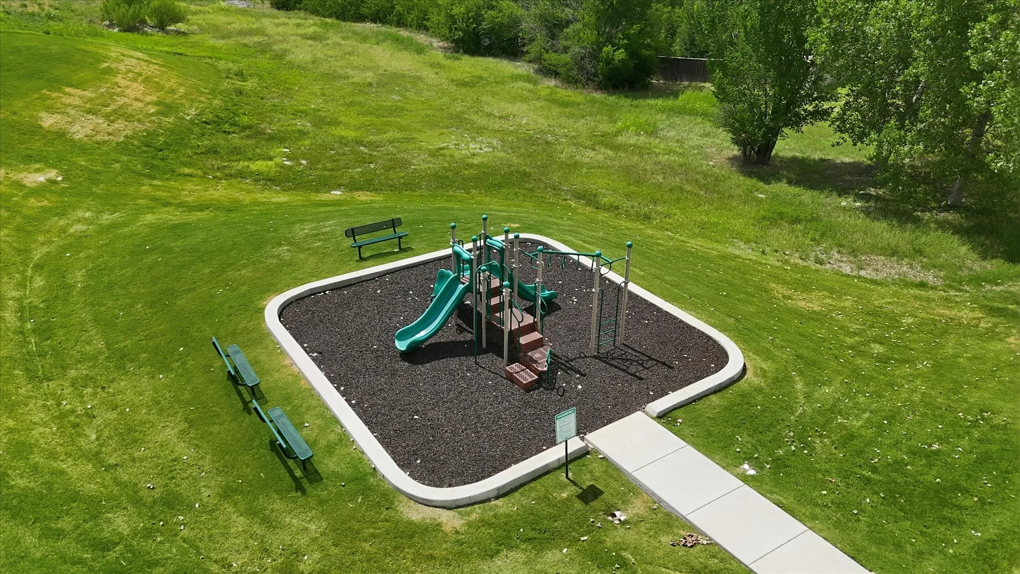 Community playground featuring a multi-level structure with slides, climbing elements, and a soft ground covering