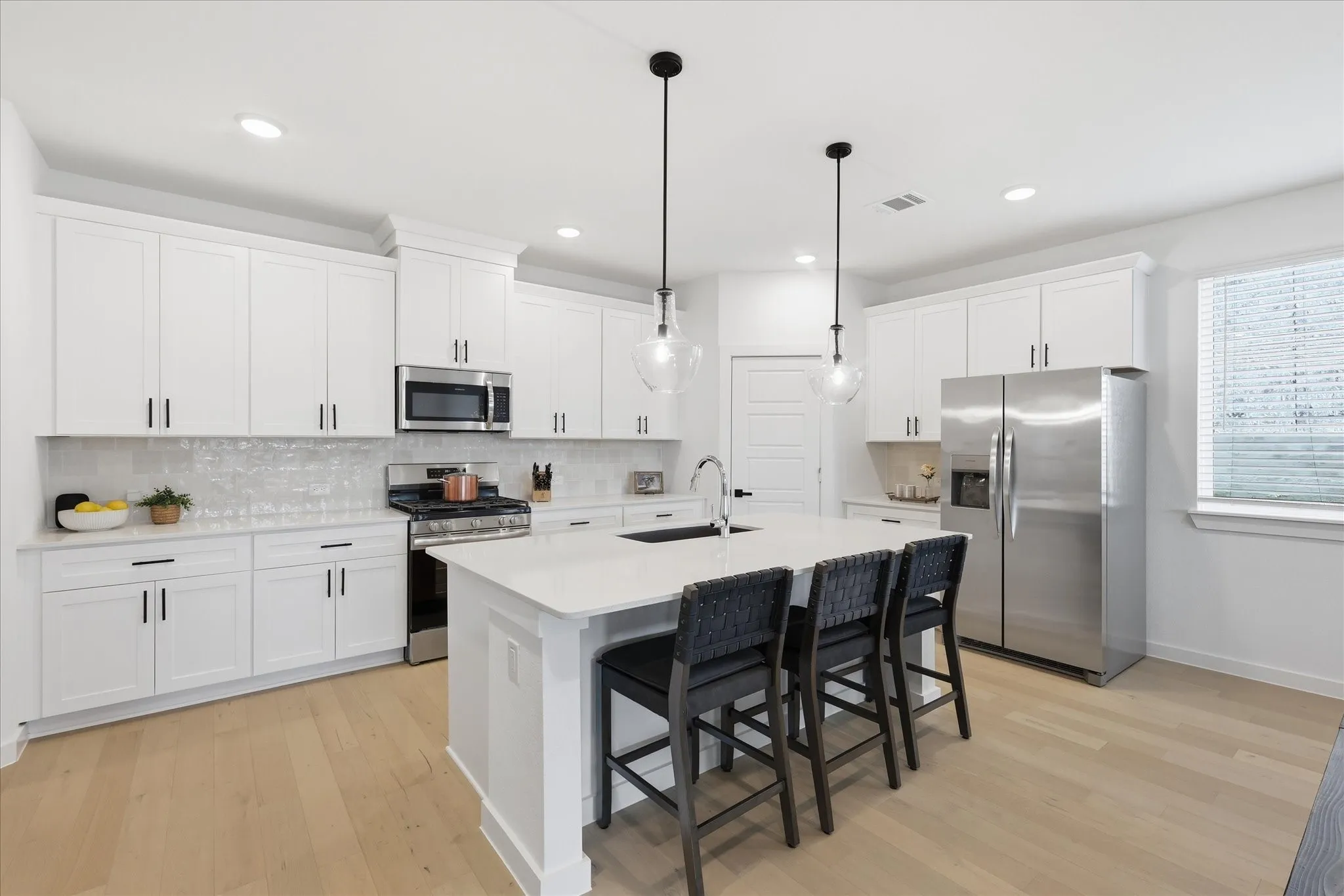 Kitchen with ample cabinetry and prep space. Quartz countertops and a central island with seating for casual morning breakfasts and snack time.