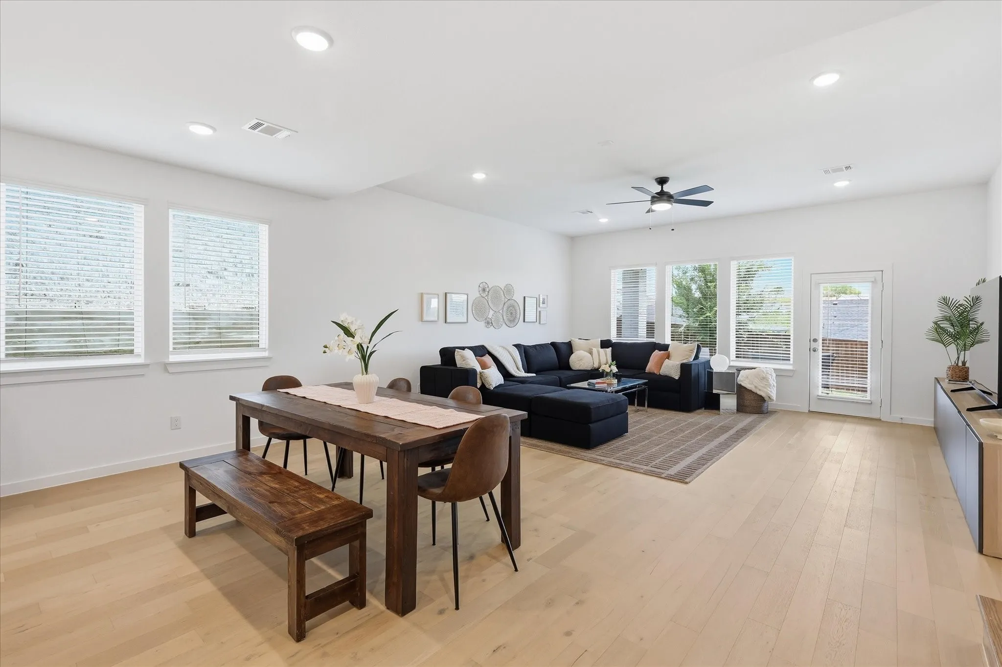 Spacious open-concept living area with a dedicated dining area that flows seamlessly into the living area. The rooms is flooded with natural light from the many windows.