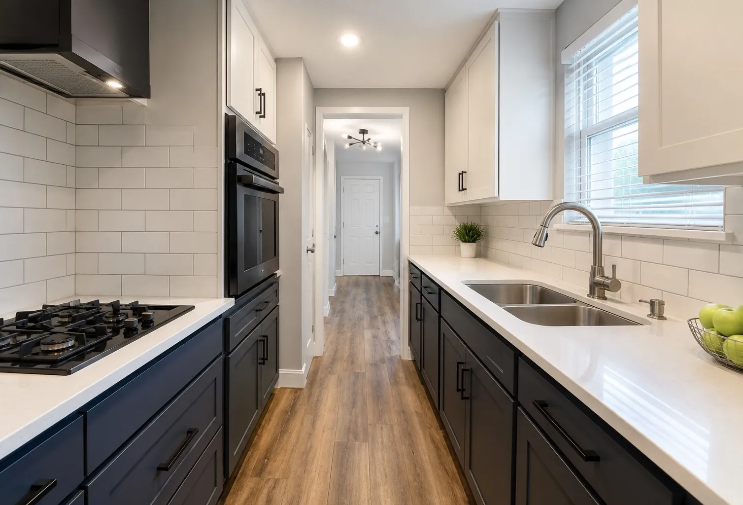 Kitchen featuring black and white cabinetry, a built-in oven, a gas cooktop, a double basin stainless steel sink, and wood-finish flooring