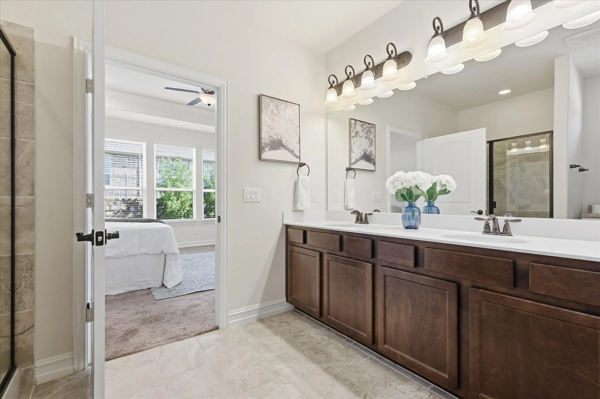 Dual sink vanity with dark wood cabinetry and white countertops
