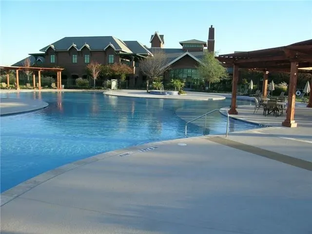 Expansive multi-level pool with integrated spa and surrounding concrete decking