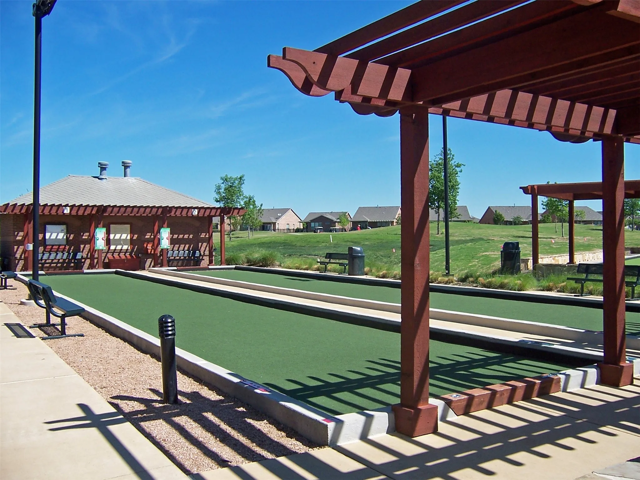 Dual bocce ball courts featuring artificial turf surfaces and concrete borders
