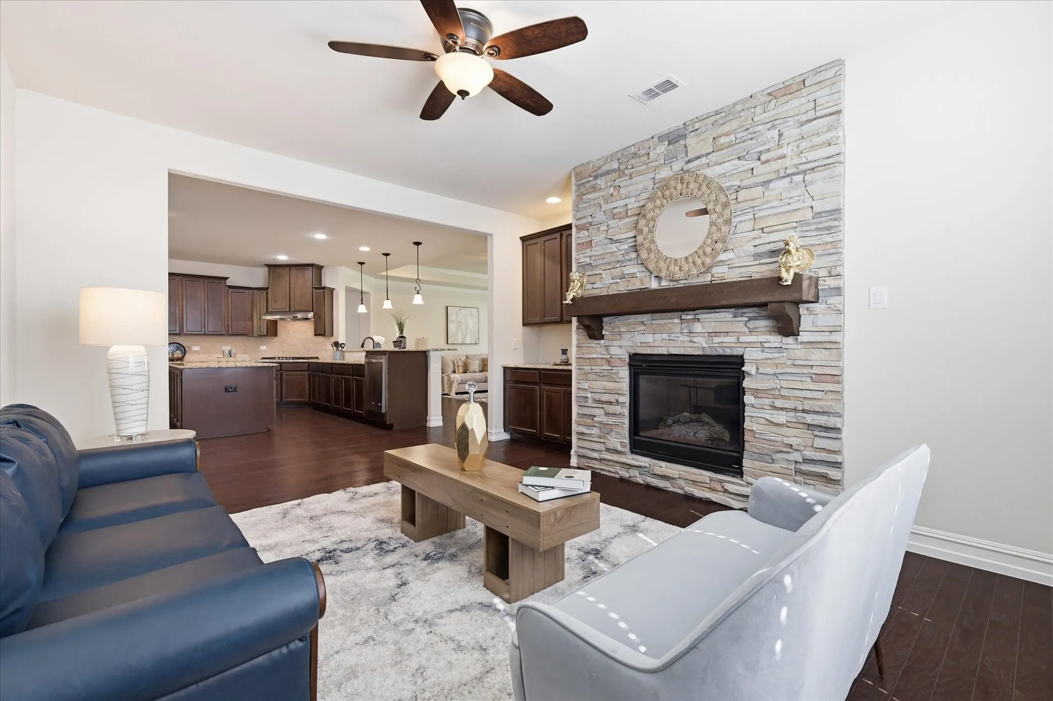 Den with a fireplace and built in cabinets opens to kitchen